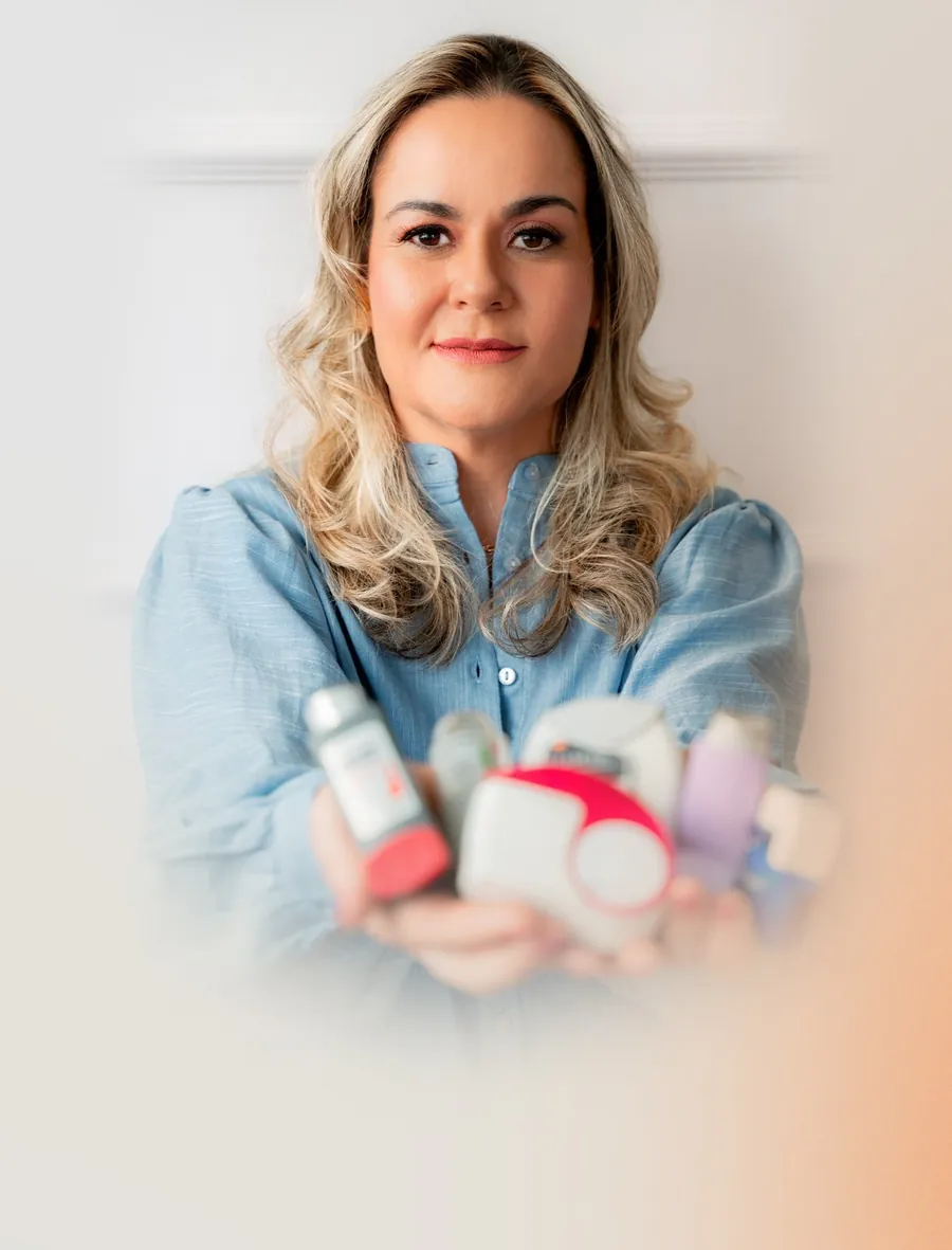 Dra. Kamilla Tonini segurando dispositivos inalatórios usados no tratamento respiratório